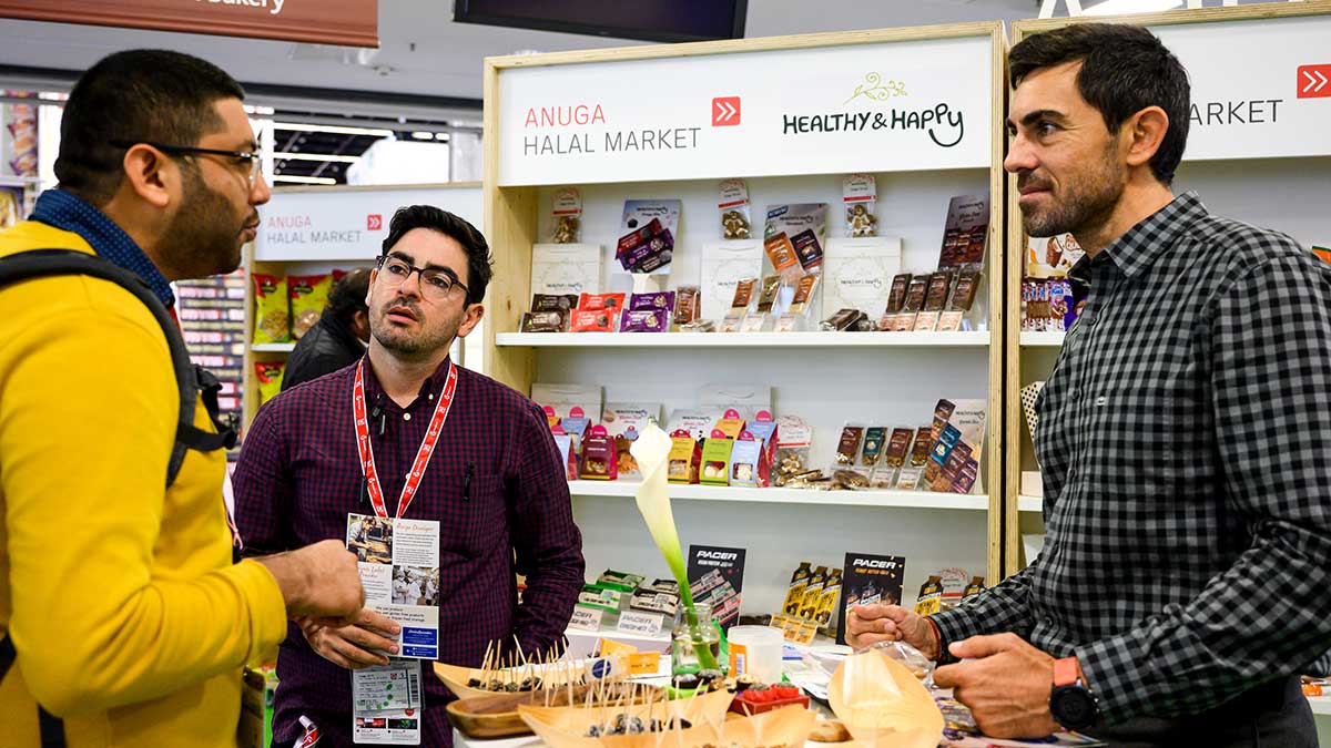 Visitors and exhibitors of the Halal Market at Anuga chat at the booth